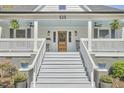 Inviting front porch with comfortable seating, ceiling fans, and a charming wooden door with glass at 523 N Main St, Graham, NC 27253