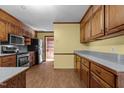 View of the kitchen featuring wood cabinets, linoleum flooring and stainless steel appliances at 5437 Grasshopper Rd, Raleigh, NC 27610
