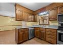 Eat-in kitchen features wood cabinets, stainless steel appliances, and a window over the sink at 5437 Grasshopper Rd, Raleigh, NC 27610