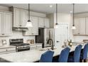 Modern kitchen features a spacious island, granite countertops, stainless steel appliances, and pendant lighting at 549 Freedom Trail Dr, Willow Springs, NC 27592