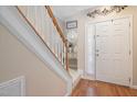 Inviting foyer featuring hardwood floors, staircase, and ample natural light filtering through a window at 5569 Sea Daisy Dr, Raleigh, NC 27606