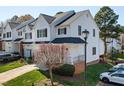 View of well-maintained townhome featuring green lawn, attached garages, and manicured landscaping at 5569 Sea Daisy Dr, Raleigh, NC 27606