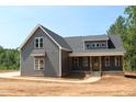 Charming two-story home featuring a covered front porch, gray siding, and well-manicured landscaping at 65 Stream View Way, Spring Hope, NC 27882