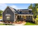 Inviting two-story home featuring a covered front porch, complemented by lush landscaping and a welcoming entrance at 65 Stream View Way, Spring Hope, NC 27882
