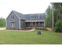 Beautiful exterior view with gray siding, a welcoming porch, and a well-manicured lawn at 65 Stream View Way, Spring Hope, NC 27882