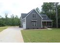 Home exterior with an attached garage, well-kept lawn, and a covered front porch at 65 Stream View Way, Spring Hope, NC 27882