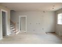 Spacious living room with staircase and natural light through large windows at 65 Stream View Way, Spring Hope, NC 27882