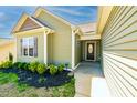 A welcoming home entrance with an accent window and landscaping, offering curb appeal at 6808 Lakinsville Ln, Raleigh, NC 27610