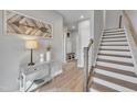 Inviting foyer with wood floors, a staircase, decorative accents, and a glimpse into the mudroom at 818 Lilyquist Way, Wake Forest, NC 27587