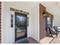 Close-up view of the front door and porch with brick detailing and outdoor seating at 8215 Cushing St, Raleigh, NC 27613