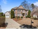 Charming two-story brick home featuring manicured landscaping, traditional architectural details, and an inviting front porch at 116 Arlen Park Pl, Holly Springs, NC 27540