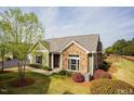 Well-maintained home featuring stone accents, light green siding, and a beautifully landscaped yard at 1503 Orchard Villas Ave, Apex, NC 27502