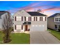 Charming two-story home with a well-manicured lawn, attached two-car garage and complementary landscaping at 151 Kutter Dr, Elon, NC 27244