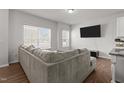 Bright living room with a comfortable sofa, large windows, and modern entertainment setup at 1805 Kauri Cliffs Dr, Fuquay Varina, NC 27526