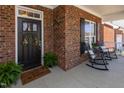 Inviting front porch featuring rocking chairs and a beautiful brick facade at 187 Moss Creek Pl, Fuquay Varina, NC 27526