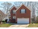 Charming two-story brick home with an attached two-car garage and a well-maintained front lawn at 2026 Prairie Ridge Ct, Fuquay Varina, NC 27526