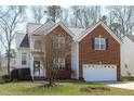 Charming two-story house with partial brick front, attached garage, manicured lawn, and mature landscaping at 2026 Prairie Ridge Ct, Fuquay Varina, NC 27526