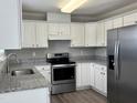 Well-equipped kitchen with stainless steel appliances, granite countertops, and white cabinetry at 2109 Henniker St, Apex, NC 27523