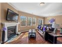 Cozy living room with a fireplace, hardwood floors, and large windows at 2216 Tanners Mill Dr, Durham, NC 27703