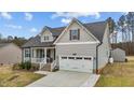 Charming home featuring a 2-car garage, inviting front porch, manicured lawn, and stylish exterior finishes at 240 Northview Dr, Middlesex, NC 27557