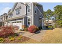 Inviting townhome exterior featuring a beautifully landscaped walkway, two-car garage, and manicured lawn at 2422 Pecan Ridge Way, Apex, NC 27502