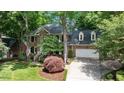 Charming brick home with a two-car garage, manicured lawn, and mature trees at 306 Lochside Dr, Cary, NC 27518