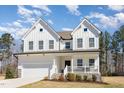 Charming two-story white farmhouse with a welcoming front porch and well-maintained landscaping at 31 E Dentaires Way, Willow Springs, NC 27592