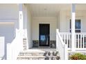 Inviting front entrance featuring stone steps, white railing and a black front door at 31 E Dentaires Way, Willow Springs, NC 27592