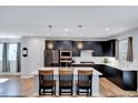 Modern kitchen with stainless steel appliances, dark cabinetry, and a large white quartz island with pendant lighting at 3417 Mission Olive Pl, New Hill, NC 27562