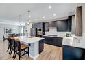 Stylish eat-in kitchen with stainless steel appliances, dark cabinets, quartz counters and island seating at 3417 Mission Olive Pl, New Hill, NC 27562