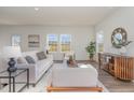 Bright living room featuring neutral furniture, wood floors, and large windows overlooking the backyard at 402 Suhani Ln, Clayton, NC 27520