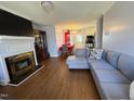 Cozy living room featuring a fireplace, hardwood floors, and an open floor plan to the dining area at 472 Cedar Ln, Mebane, NC 27302