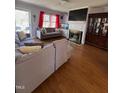 Comfortable living room showcasing hardwood floors, a fireplace, and large windows for natural light at 472 Cedar Ln, Mebane, NC 27302