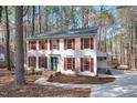 Classic colonial-style home featuring a white exterior, red shutters, and a well-manicured front yard at 4910 Highgate Dr, Durham, NC 27713