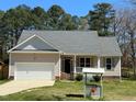 Front exterior showcasing a cozy single-Gathering home with a well-kept lawn and attached garage at 495 Cheves Rd # 495, Zebulon, NC 27597