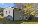 The backyard of a gray brick house shows the side with steps to the back and new windows at 539 N Oneil St, Clayton, NC 27520