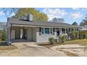 Single-story house boasting grey brick exterior, classic black shutters, and a convenient covered carport at 539 N Oneil St, Clayton, NC 27520