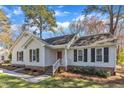 A charming home featuring a brick foundation, white siding, and a welcoming red front door at 5508 Lake Garden Ct, Raleigh, NC 27610