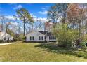 Beautifully landscaped front yard view of a traditional home with mature trees and green lawn at 5508 Lake Garden Ct, Raleigh, NC 27610