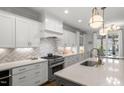 Bright kitchen featuring white cabinetry, stainless steel appliances, and a large island with seating at 5811 Shawood Dr, Raleigh, NC 27609
