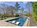 Backyard pool area with in-pool loungers and lush landscaping, perfect for relaxation at 5811 Shawood Dr, Raleigh, NC 27609