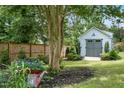 Backyard shed with garden and flowers in a fenced in backyard at 5811 Shawood Dr, Raleigh, NC 27609