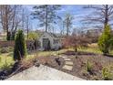 Backyard shed with charming details, nestled among mature trees and greenery at 5811 Shawood Dr, Raleigh, NC 27609