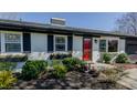 Charming white brick home with black shutters, a bright red front door, and flower box accents at 761 S Eighth St, Mebane, NC 27302