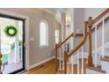 Elegant foyer featuring hardwood floors, staircase, and an arched window, creating a warm and inviting entrance at 7816 Tylerton Dr, Raleigh, NC 27613