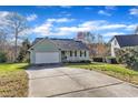 Beautiful home with an attached garage and long driveway surrounded by mature trees at 803 Trail Stream Way, Knightdale, NC 27545