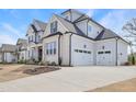 Spacious home with a three-car garage, showcasing modern design and a well-manicured lawn at 83 Inspiration Way, Fuquay Varina, NC 27526