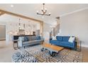 Open-concept living room with hardwood floors and a stylish rug, seamlessly connecting to the kitchen at 83 Inspiration Way, Fuquay Varina, NC 27526
