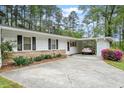 Exterior elevation features a white facade, stone accents, and a convenient carport for parking at 911 Williams Rd, Raleigh, NC 27610