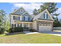Inviting home with a two-car garage, and a manicured lawn surrounded by green foliage at 1033 Jensen Grove Ct, Fuquay Varina, NC 27526
